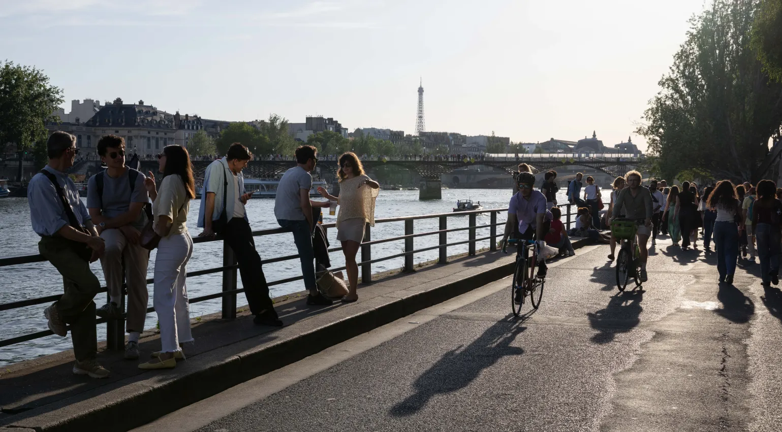 Photograph of people walking and cycling along the river Seine in Paris.