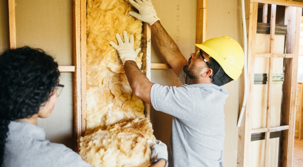 builders adding insulating to wall cavity