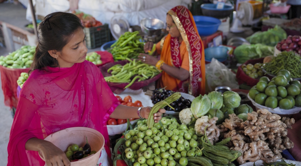 woman buying fruit and veg from street stall