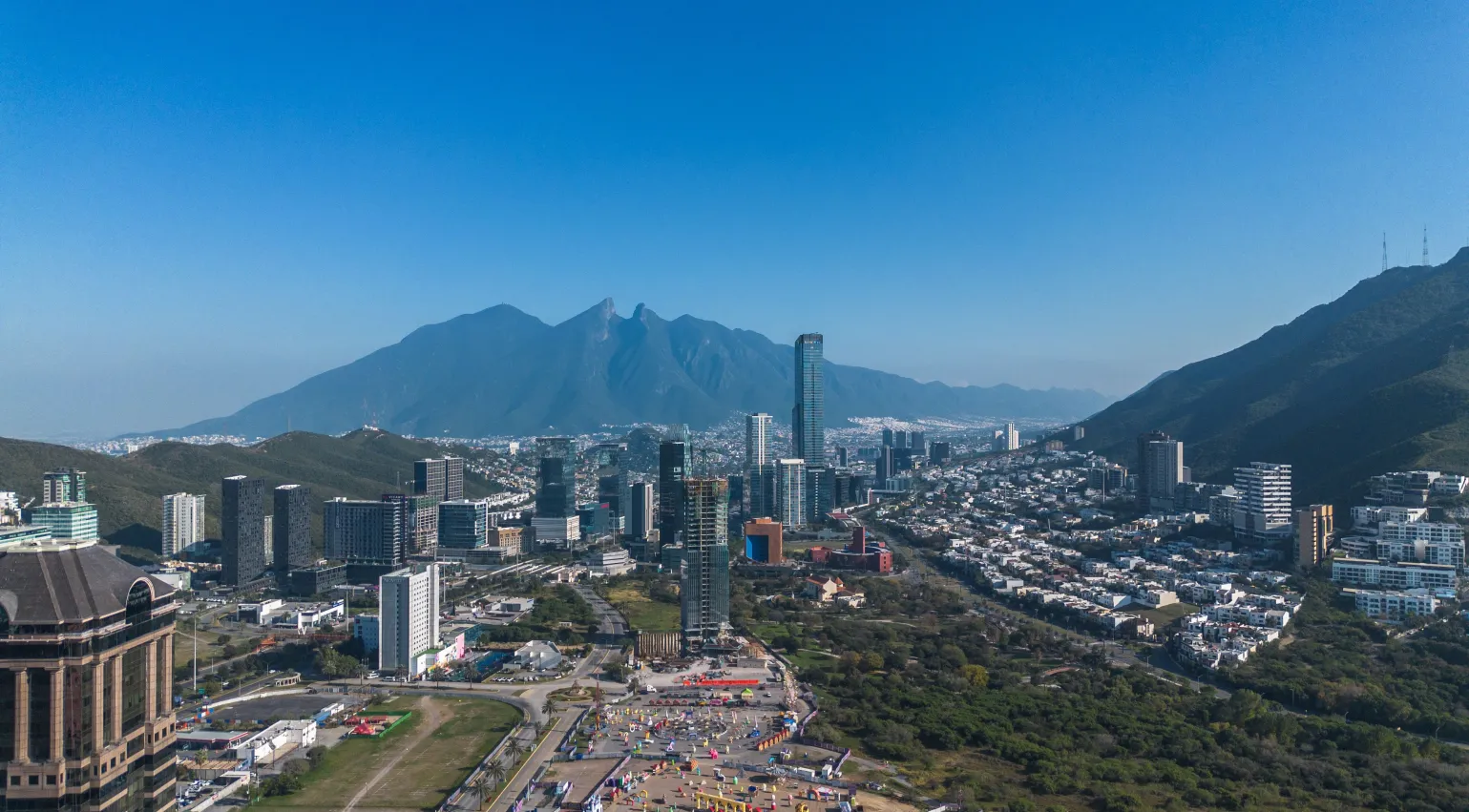 Aerial view of Monterrey with mountains in the background and buildings and roads in the foreground